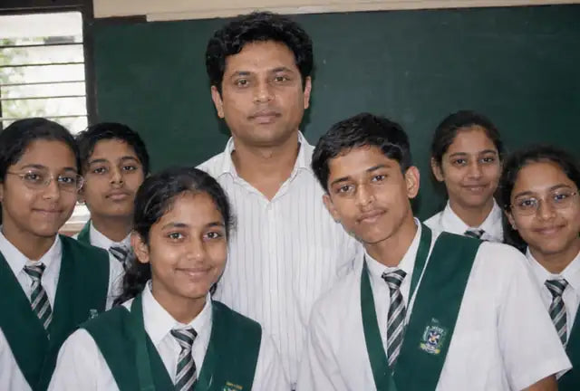 Siddharth Shukla standing with a group of his school students in the classroom