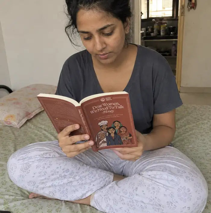 Rutvi reading the Dear Women, We Need to Talk - Money book, one chapter at a time